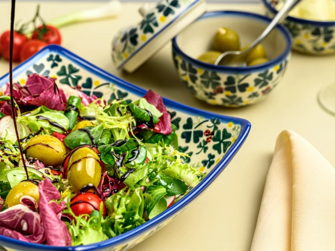 a bowl of salad with olives and tomatoes